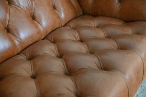 Gebruikte moderne chesterfield bank met geknoopte zitting in cognac kleur