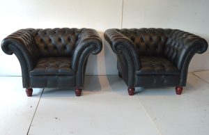 Een vleugje vintage stijl in huis met deze set van 2 lowback Chesterfield stoelen in effen zwart leer. Doorleefde look met karaktervolle gebruikerssporen. 14229-14230