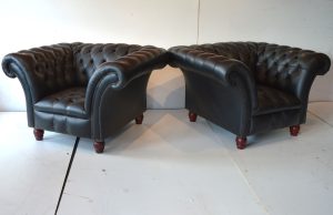 Een vleugje vintage stijl in huis met deze set van 2 lowback Chesterfield stoelen in effen zwart leer. Doorleefde look met karaktervolle gebruikerssporen. 14229-14230